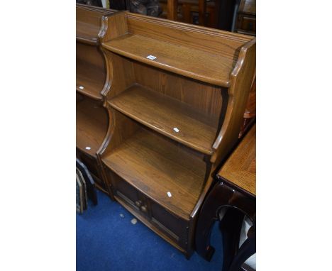 AN ERCOL ELM CASCADE BOOKCASE, with two tier shelving above double cupboard base