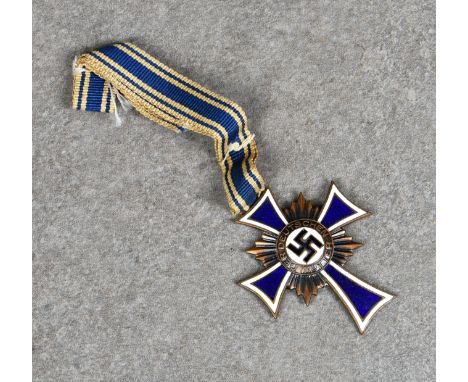 A German 'Der Deutschen Mutter' (German mothers cross) medal cobalt blue enamel cross with white rim on sunburst roundel, cen