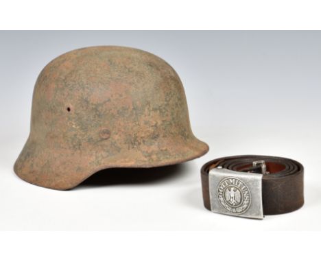 A WW2 German M40 helmet in semi-relic condition and German Army Belt the helmet with traces of overpainted camo, inner band, 