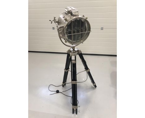 A contemporary chrome finish floor lamp, fashioned as a spotlight, on an ebonised tripod stand, approximate height 190cm.