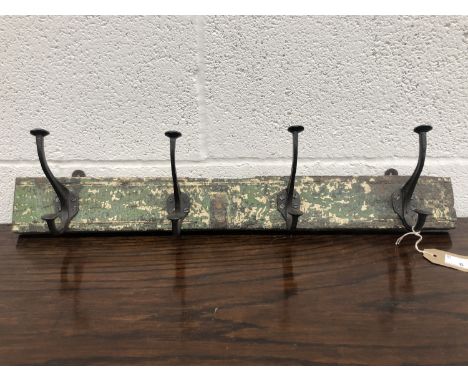 A set of metal coat hooks, attached to a rectangular wood panel. The hooks previously purchased from East of Eden, Penzance, 