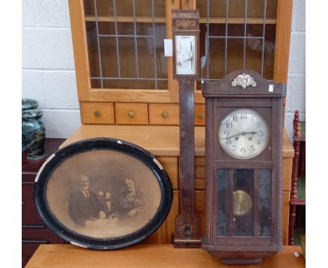 A Legris Opticien barometer, damaged, together with a framed Victorian photographic print and a wall-mounted cased clock.