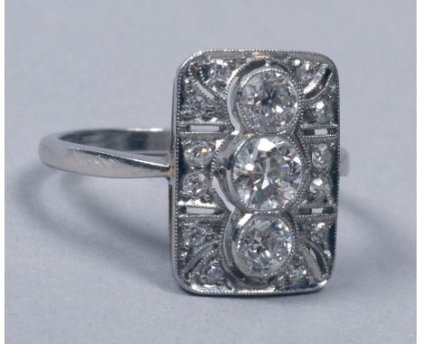 A diamond platinum set ring of Art Deco style with a rectangular setting, having three central principal stones.