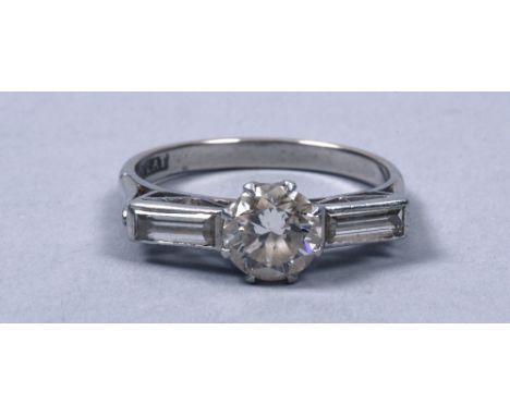 A Platinum and diamond set Art Deco ring having one central solitaire diamond .75ct flanked by two baguette diamonds in a rai