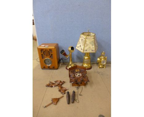 A quartz cuckoo clock, a Steepletone radio, brass candlestick telephone, table lamp and weather station