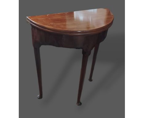 A 19th Century mahogany demi lune card table, the hinged top above a plain frieze raised upon turned tapering legs with pad f