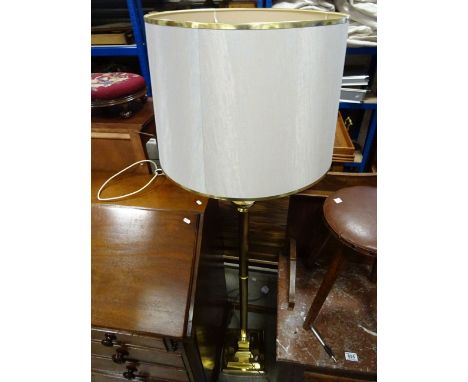 A contemporary brass effect standard lamp and shade of corinthium form raised on a square base.