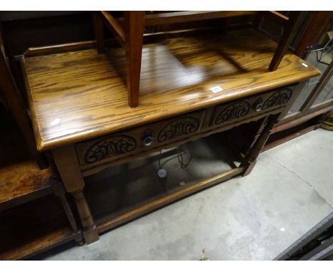 A 20th century oak console side table with two drawers raised on turned supports.