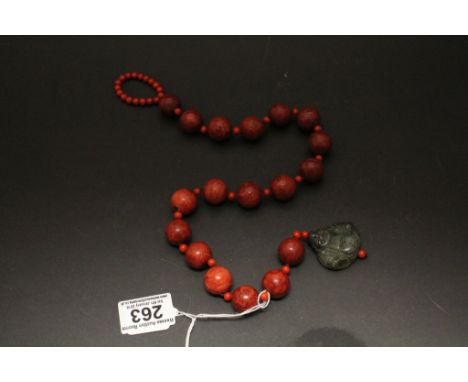 An amber style necklace with Jade crisp in the form of a Buddha