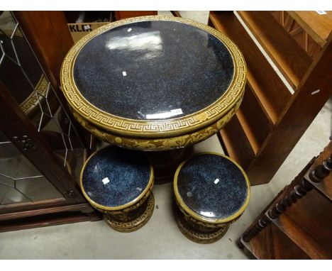 A circular oriental style ceramic stoneware table and stools with dragon decoration. 