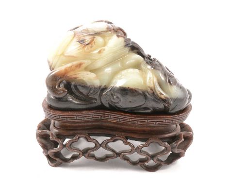 Chinese green and russet jade carving of a recumbent lion, Ming style, 8.5cm, on a bespoke hardwood stand.Condition report:Pr