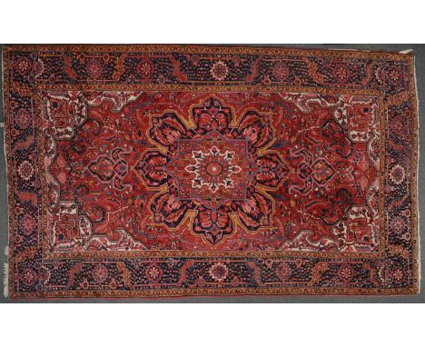 Hamadan small carpet, central floral medallion on a red ground field within guards, broad dark blue border, 347cm x 255cm.