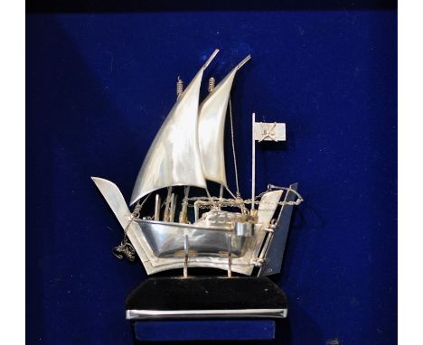  Omani silver model of a dhow / baghlah sailing vessel, Middle Eastern 20th century, with unfurled sails and the Omani flag, 