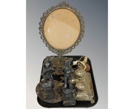 An ornate brass picture stand, trivet, desk stand, pair of patinated metal figures of harvesters, brass nutcracker in the for