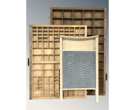 A pine and galvanised metal washboard and two type trays.