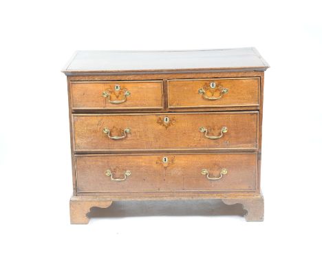 A late Georgian oak chest of drawers The rectangular two plank cleated top above an arrangement of two short and two long coc