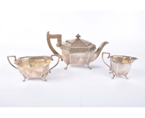 A silver three piece tea serviceOf elongated octagonal form, with angular handles, raised on four paw feet, comprising; tea p