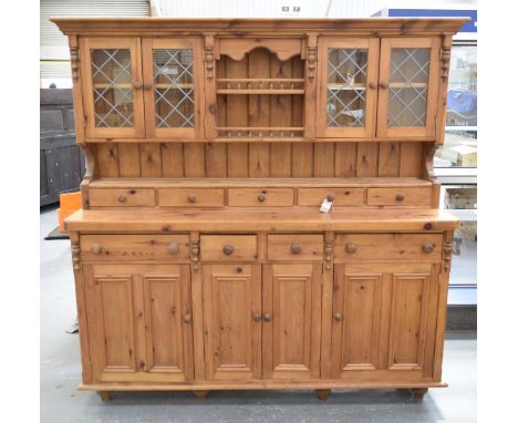 A modern pine kitchen dresserThe raised back with a moulded cornice above two central galleried shelves flanked by a pair of 