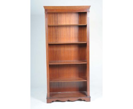 A reproduction mahogany open bookcaseWith a moulded dentil cornice above channelled uprights flanking four enclosed shelves, 