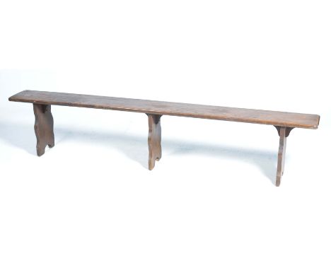A rustic oak bench,The rectangular top with rounded corners supported on three shaped bracket supports, 203x 41x 23cm.
