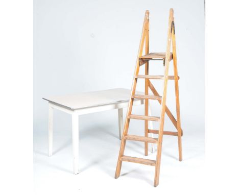A retro painted kitchen table and a set of vintage fold wooden step-laddersThe table with a rectangular Formica top raised on