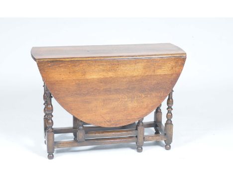 A good quality 18th Century style oval oak drop leaf dining tableThe top raised on ring turned bobbin and block supports with