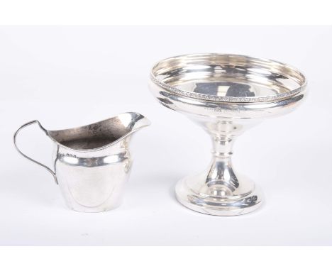 A silver tazza and silver helmet shaped jugThe tazza with a chased scrolling foliate rim raised on knopped stem and weighted 
