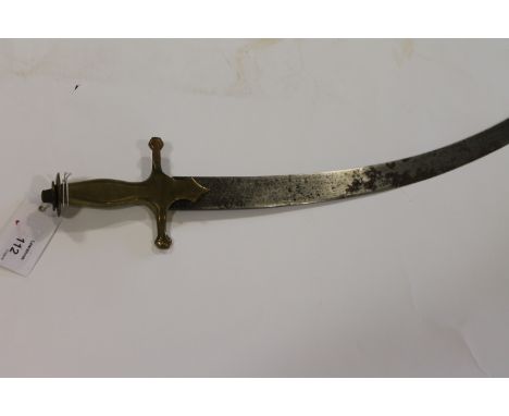 A TULWAR SWORD. A brass hilted Tulwar sword with Tigers Head pommel and 26. 1/4" length single-edged curved blade. The cast b