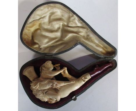 A cased Meerschaum pipe, carved with a semi naked female and another female blowing a pipe

