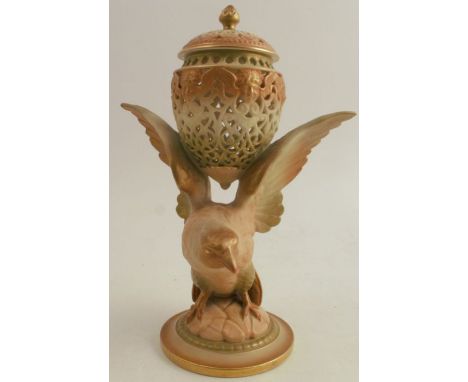 A Royal Worcester shot silk centre piece, formed as a covered reticulated vase supported on the wings of a bird, on a circula