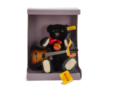 A Steiff unusual yellow tagged Bobby Musical Teddy Bear black, with guitar, in original box, 1993 (slight damage to box)