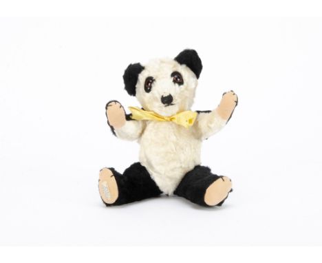 A post-war Chiltern artificial silk push Panda Hugmee,  with black and white plush, orange and black glass eyes, black felt b