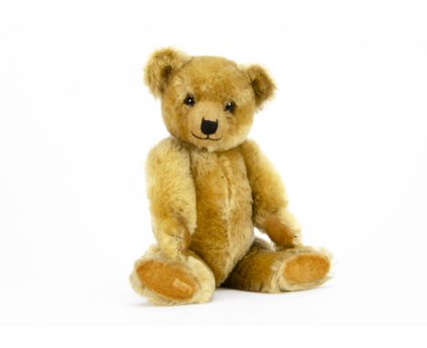 A fine Chiltern 1930s Hugmee teddy bear, with blonde mohair, clear and black glass eyes with remains of brown painted backs, 
