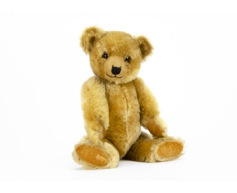 A fine Chiltern 1930s Hugmee teddy bear, with blonde mohair, clear and black glass eyes with remains of brown painted backs, 