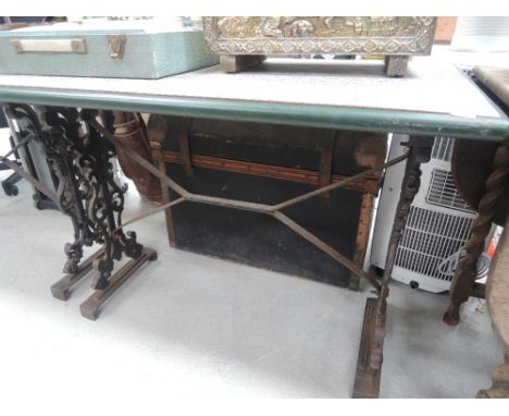 A vintage metal frame garden table with later top