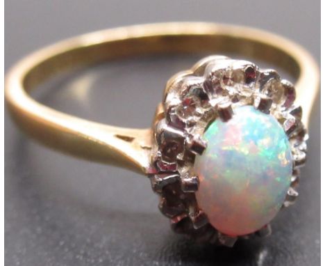 yellow metal opal and diamond ring, the central oval opal surrounded by a halo of diamonds, unmarked, size N1/2, 3.2g 