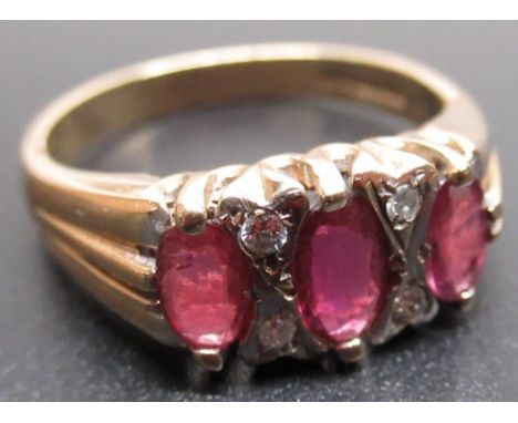 9ct yellow gold ring set with three oval cut rubies and four brilliant cut diamonds, stamped 375, size N, 3.4g 