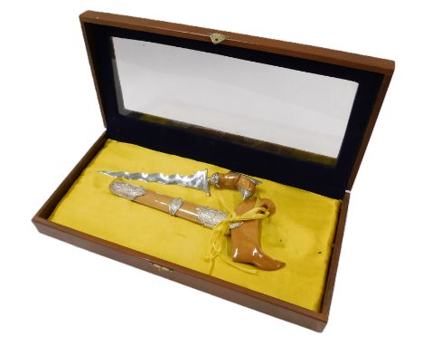 A Malayan ceremonial Kris, with silver coloured mounts to the handle and scabbard, in glazed case, the knife 34cm high.