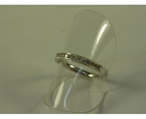 Channel set diamond half eternity ring with milgrain border stamped 750
