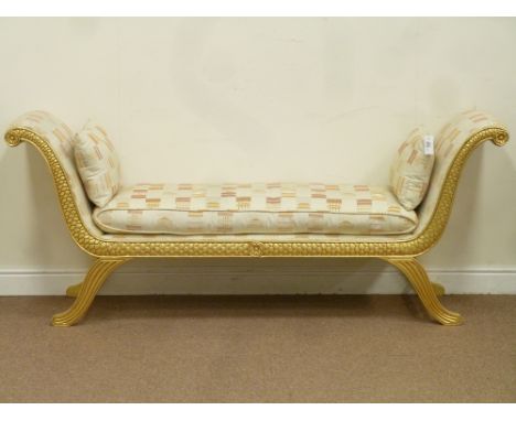 Gilt wood upholstered window chaise lounge in a Regency x-shaped style, carved fish scale detail,  by repute from Harrods of 