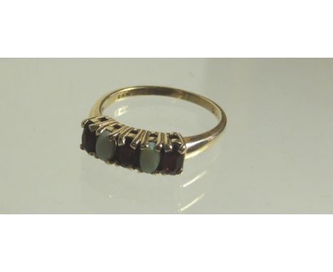 A ladies 14k gold dress ring, set with three garnets and two Cabouchon opals.  Ring size R. 