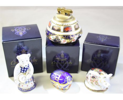 A group of four Royal Crown Derby porcelain pieces.  Comprising of a boxed millennium bug paperweight,a boxed piglet paperwei