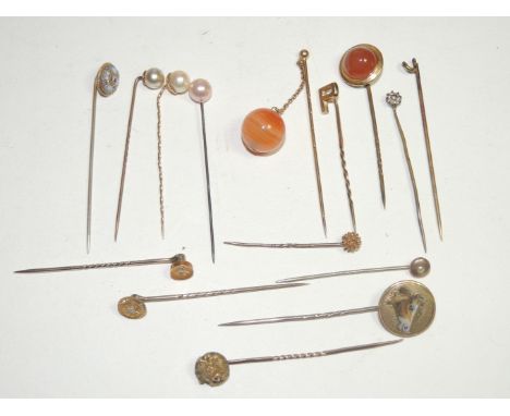 A 9ct gold tie/stick pin with the initial "P", another 9ct pin modelled as a lion's head, a 15ct pin set with a small diamond