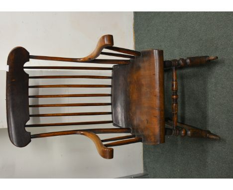 An interesting 19th Century rocking chair with stick back, shaped seat with "roll over" front and on turned supports