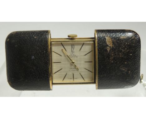 A small ladies travelling timepiece, the leather covering pulls open to reveal a square faced manual wind timepiece with line