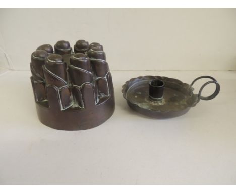 A Victorian copper jelly mould together with an Arts and Crafts copper chamber stick of simple form and with "wire" handle by