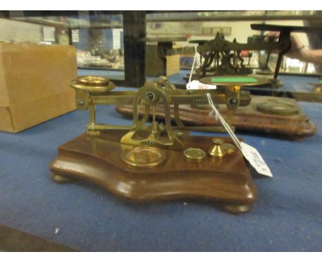 LATE 19TH CENTURY WALNUT AND BRASS POSTAL SCALE, OF TYPICAL FORM WITH SERPENTINE BASE ON BUN FEET AND STAMPED S MORDAN &amp; 