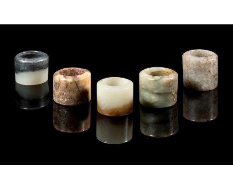 A GROUP OF FIVE JADE ARCHERS RINGS, QING DYNASTY, 18TH/19TH CENTURY comprising: a mottled greyish-celadon archers ring, 3cm h