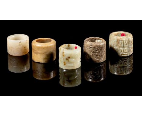 A GROUP OF FIVE JADE ARCHERS RINGS, QING DYNASTY, 18TH/19TH CENTURY comprising: a mottled green and buff archers ring, carved