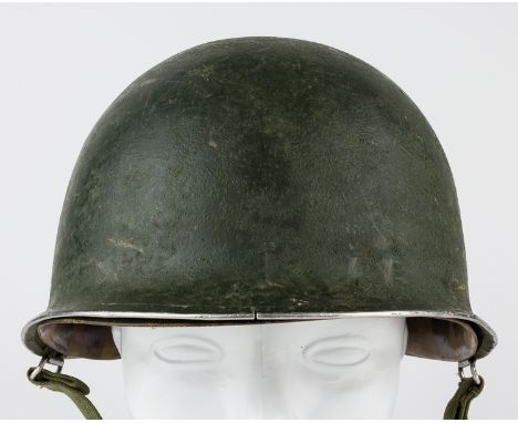AMERICAN M-1 HELMETUnited States Army M1 steel helmet shell and liner. The shell features swivel strap bales and a seam at th